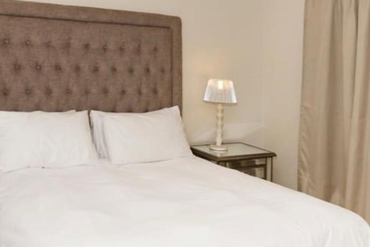 A well-maintained bedroom featuring neutral wall tones and simple finishes, providing a comfortable and clean living space.