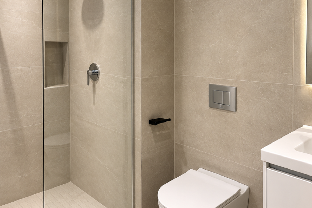 Modern bathroom featuring a walk-in shower with a rain shower head, a wall-mounted toilet, and a sleek vanity cabinet with integrated sink.