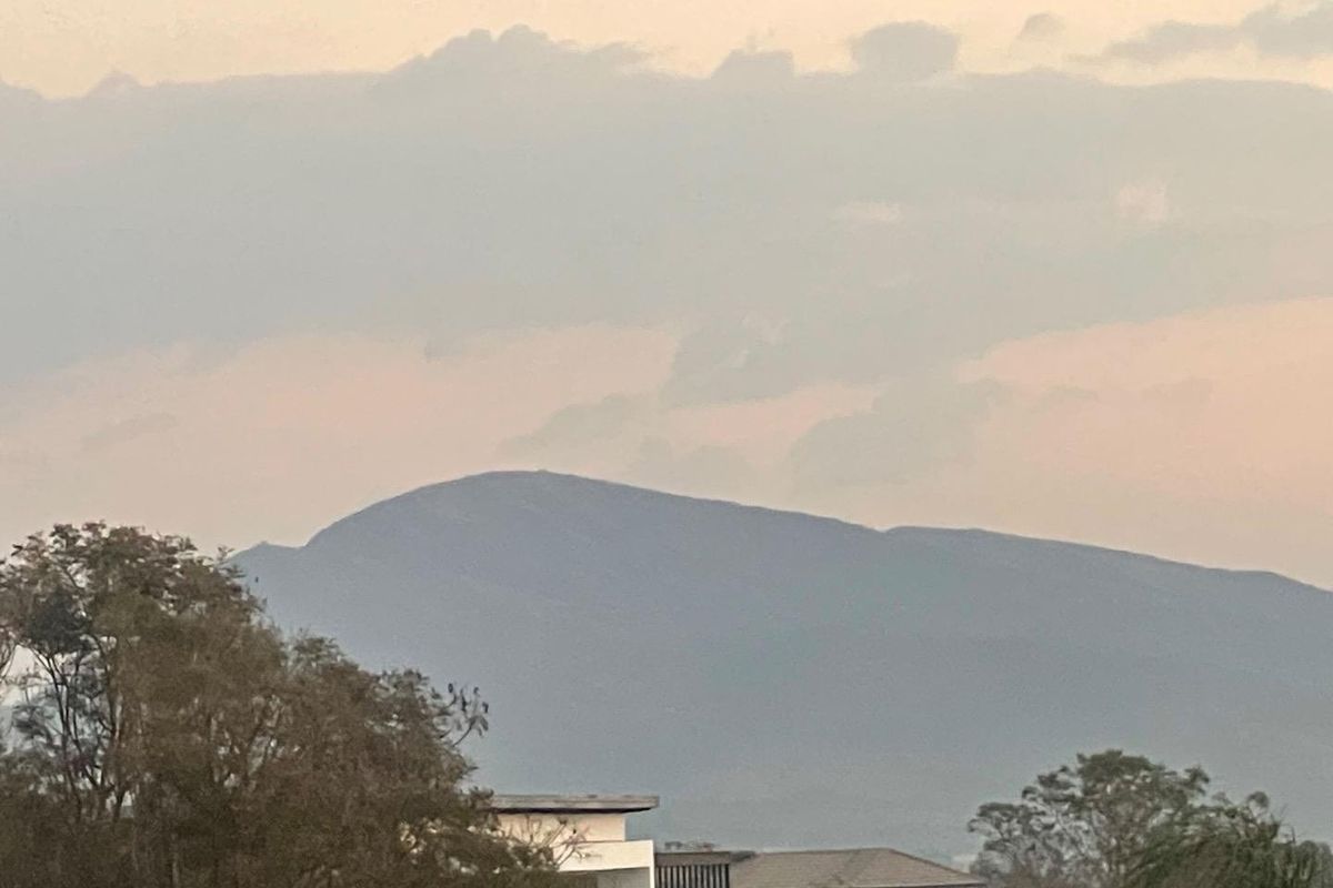 A scenic view of the surrounding mountain landscape captured during sunset.