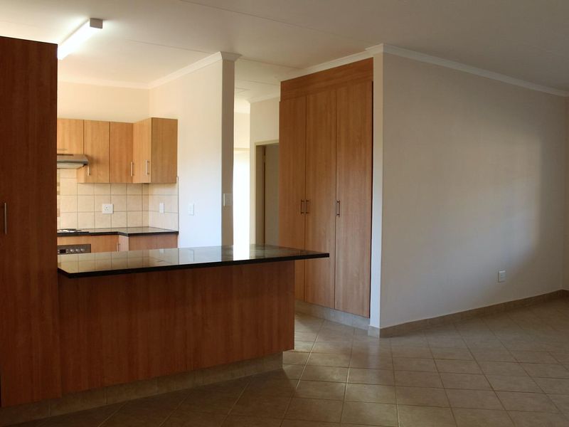Open plan living area featuring a kitchen with built-in cabinetry, granite countertops, and tiled flooring throughout.