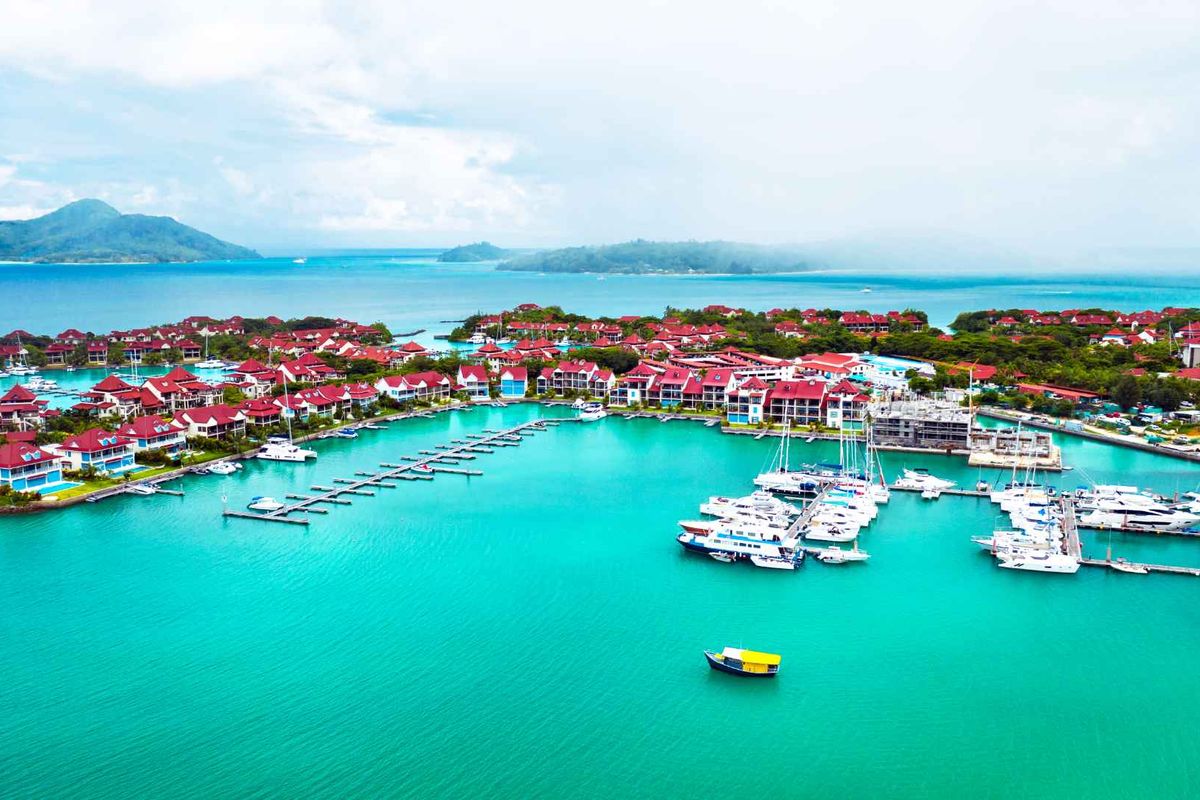 Aerial view of a coastal residential estate featuring a private marina with multiple boat slips and turquoise water.