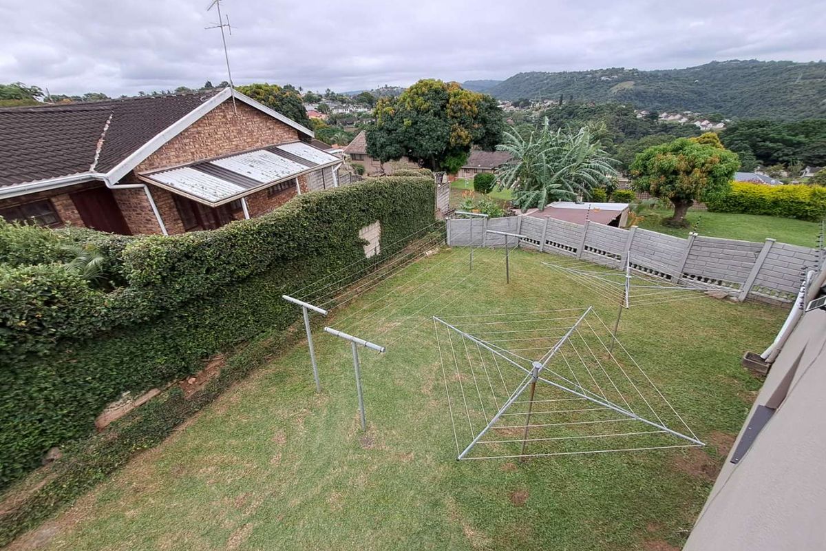 Elevated view of a private rear garden featuring a lawn, perimeter walling, and multiple fixed outdoor washing lines.