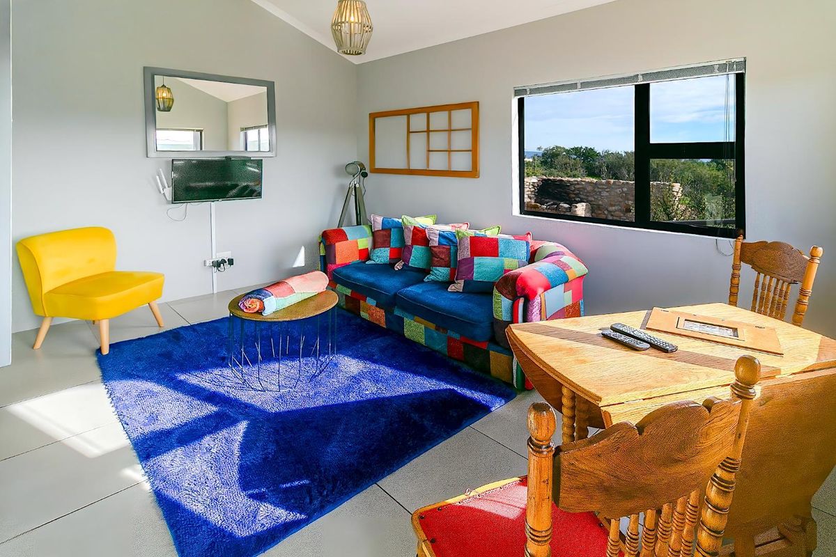 A bright living area featuring tiled flooring, large windows with natural light, and neutral wall finishes, suitable for a comfortable lodge setting.