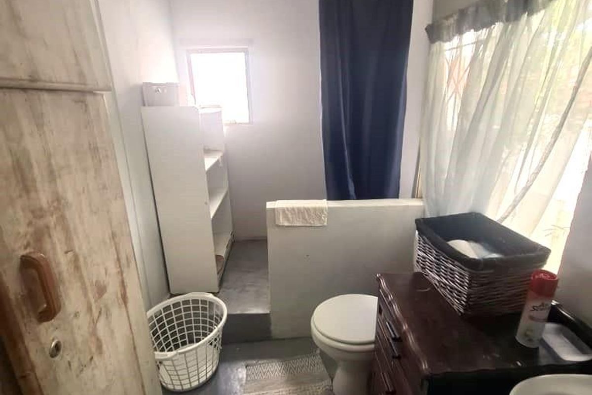 A functional bathroom featuring a shower area, toilet, and basin with basic finishes and a compact layout.