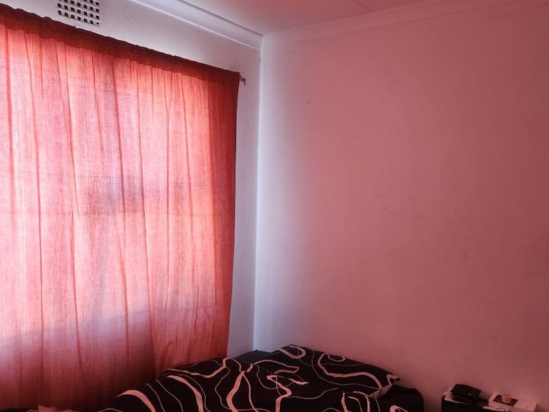 A bedroom featuring a ceiling vent and coving, currently presented with basic finishes.