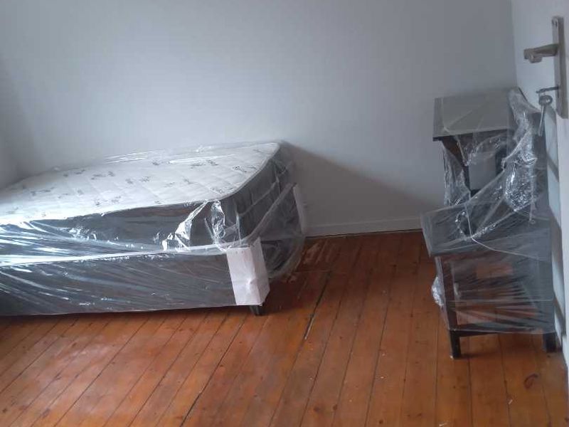A bedroom featuring polished timber flooring and a ceiling vent, presented in a vacant state.