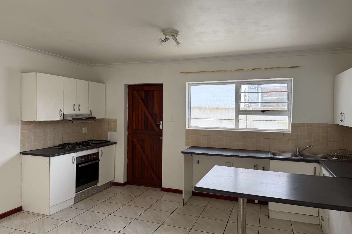 A functional kitchen featuring white cabinetry, gas hob, built-in oven, and tiled flooring, offering a blank canvas for modern updates.