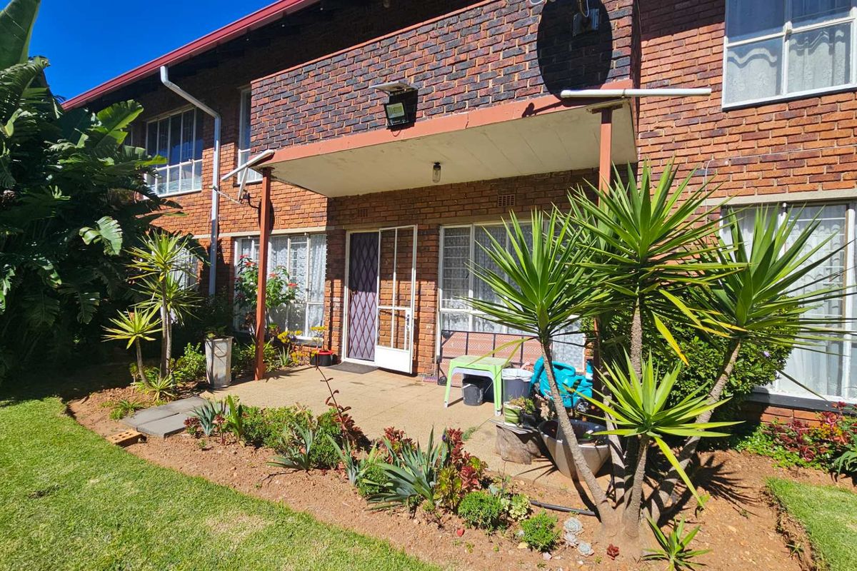 Ground floor apartment featuring a private paved patio area with direct access to the communal garden and established landscaping.