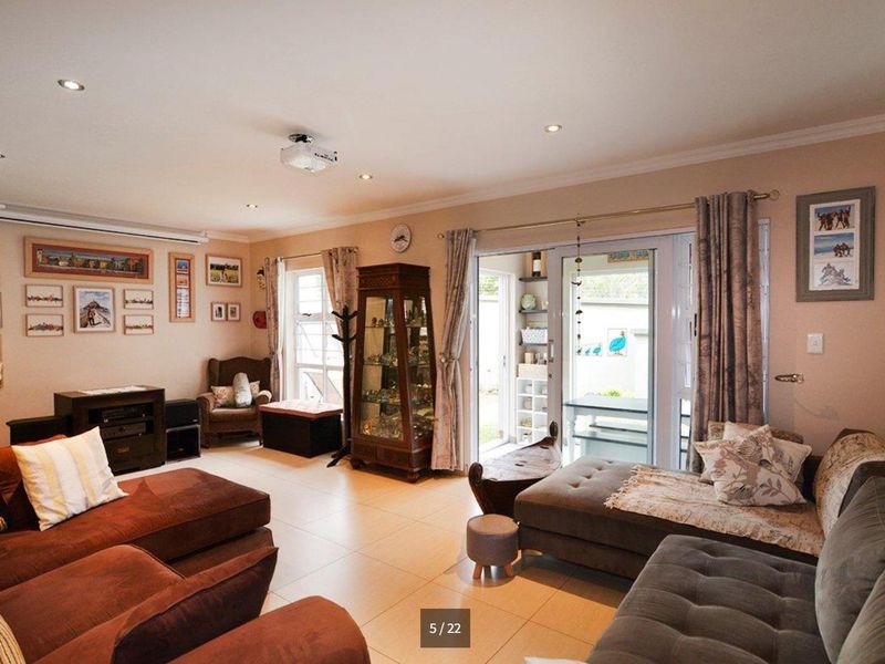 Spacious living room featuring tiled flooring, recessed downlights, and large sliding glass doors providing access to the outdoor area.