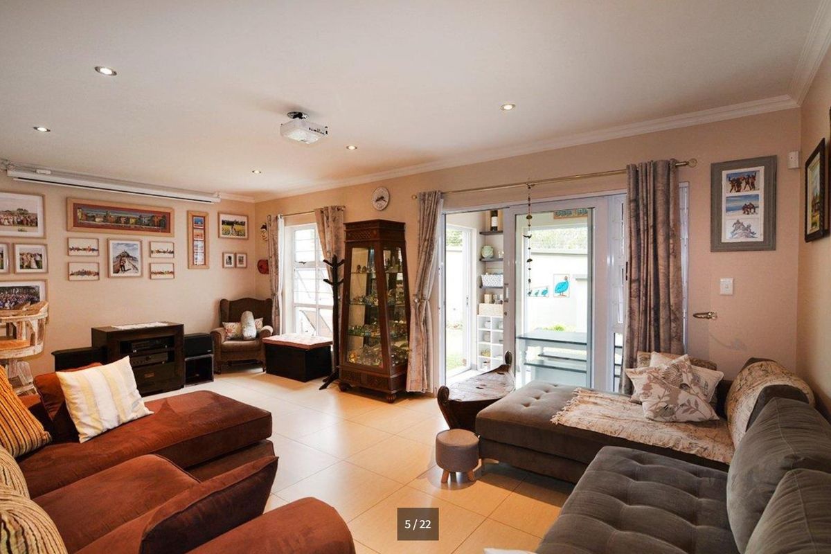Spacious living room featuring tiled flooring, recessed downlights, and large sliding glass doors providing access to the outdoor area.