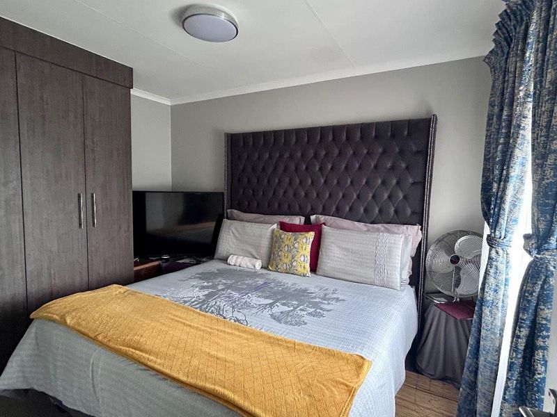 A bedroom featuring a built-in wardrobe and a ceiling light fixture.