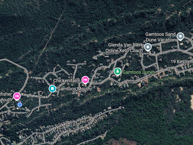 An aerial satellite view of the Gamtoos Mouth residential area, showcasing the surrounding coastal landscape, sand dunes, and local road infrastructure.
