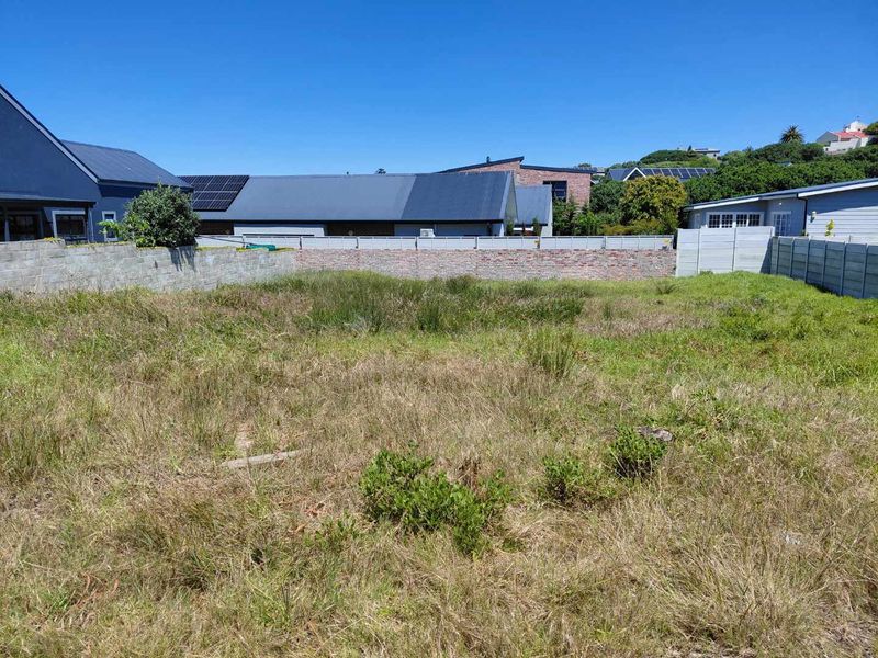A vacant residential plot featuring established boundary walls and precast concrete fencing, ready for development.