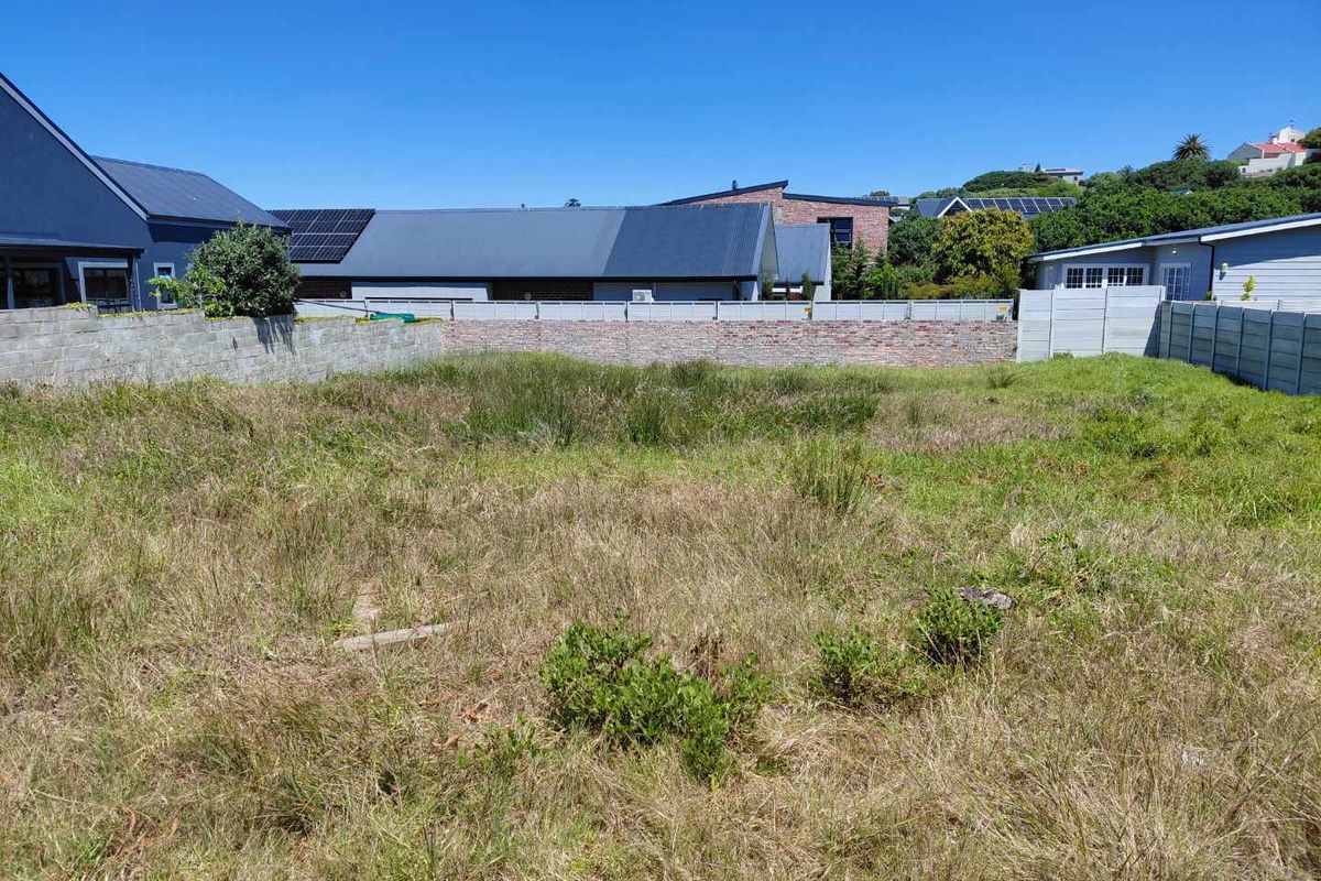 A vacant residential plot featuring established boundary walls and precast concrete fencing, ready for development.