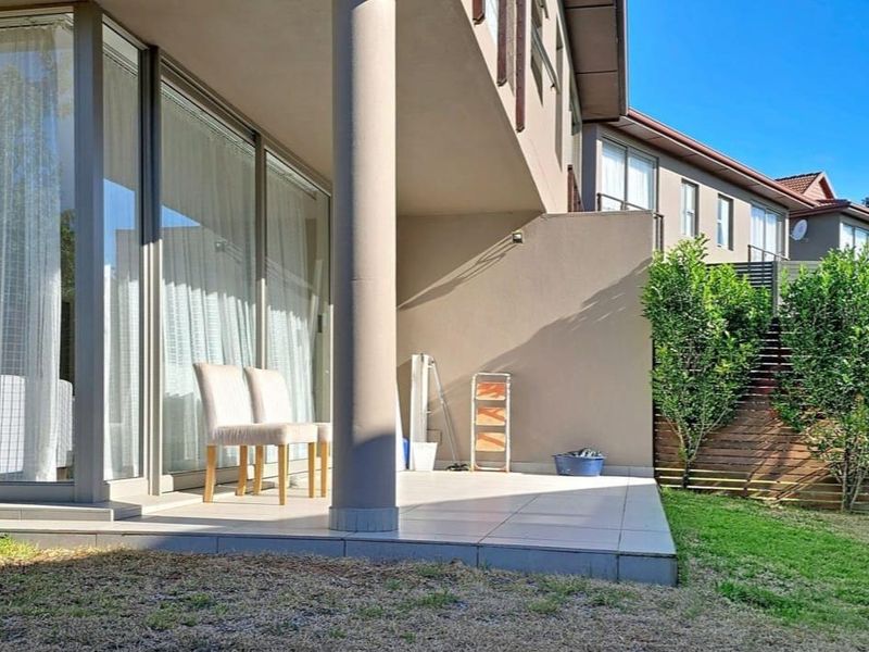 A covered patio area featuring tiled flooring, a structural column, and large sliding glass doors providing access to the interior living space.