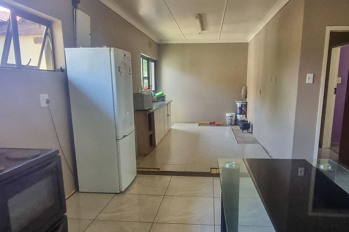 A functional kitchen space featuring tiled flooring, built-in cabinetry, and a layout ready for renovation or modernization.