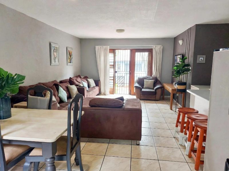 Open-plan living and dining area featuring tiled flooring and a sliding glass door leading to an outdoor space.