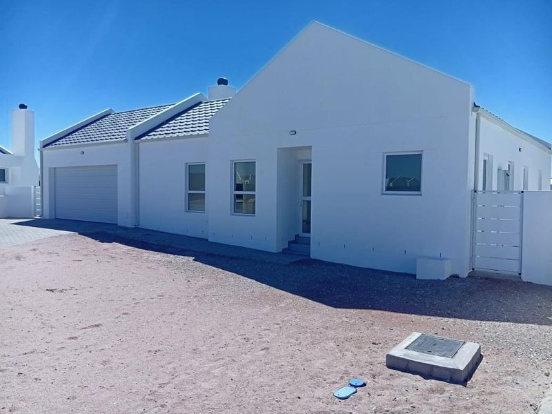 A modern single-story house exterior featuring a clean white facade, tiled roof, integrated garage, and secure gated entrance.