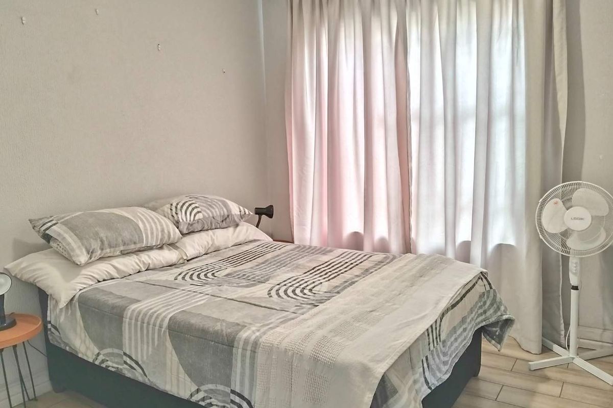 A functional bedroom featuring tiled flooring and window curtain treatments, ready for a refresh to enhance its overall appeal.
