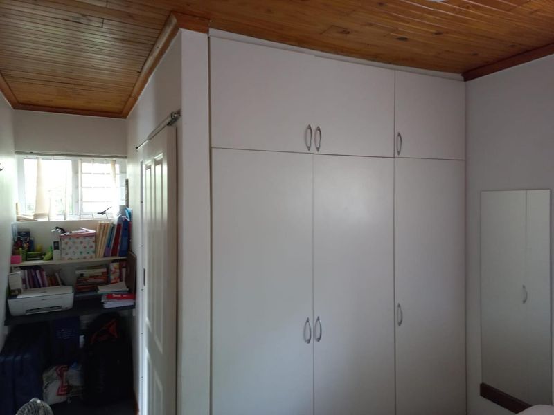 Bedroom featuring built-in cupboards and a timber-clad ceiling, providing functional storage space within the room.