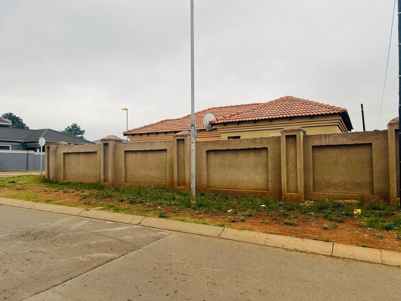 Street view of the property showing the perimeter wall, tiled roof, and exterior facade from the road.