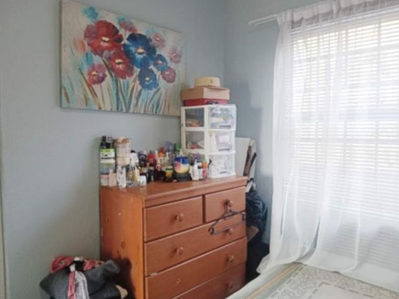 A bedroom featuring a window with a curtain rod, providing natural light to the space.
