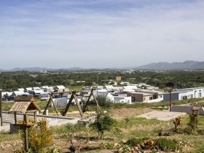 Elevated view overlooking a residential development with surrounding natural landscape and recreational features in the foreground.