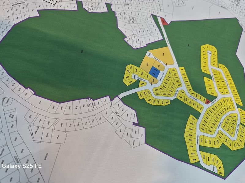 A printed site development plan showing the layout of residential plots within the estate.