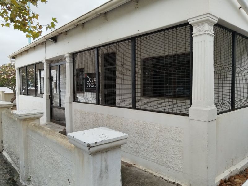 Front exterior view of the property featuring a covered entrance area with security mesh screening and decorative columns.