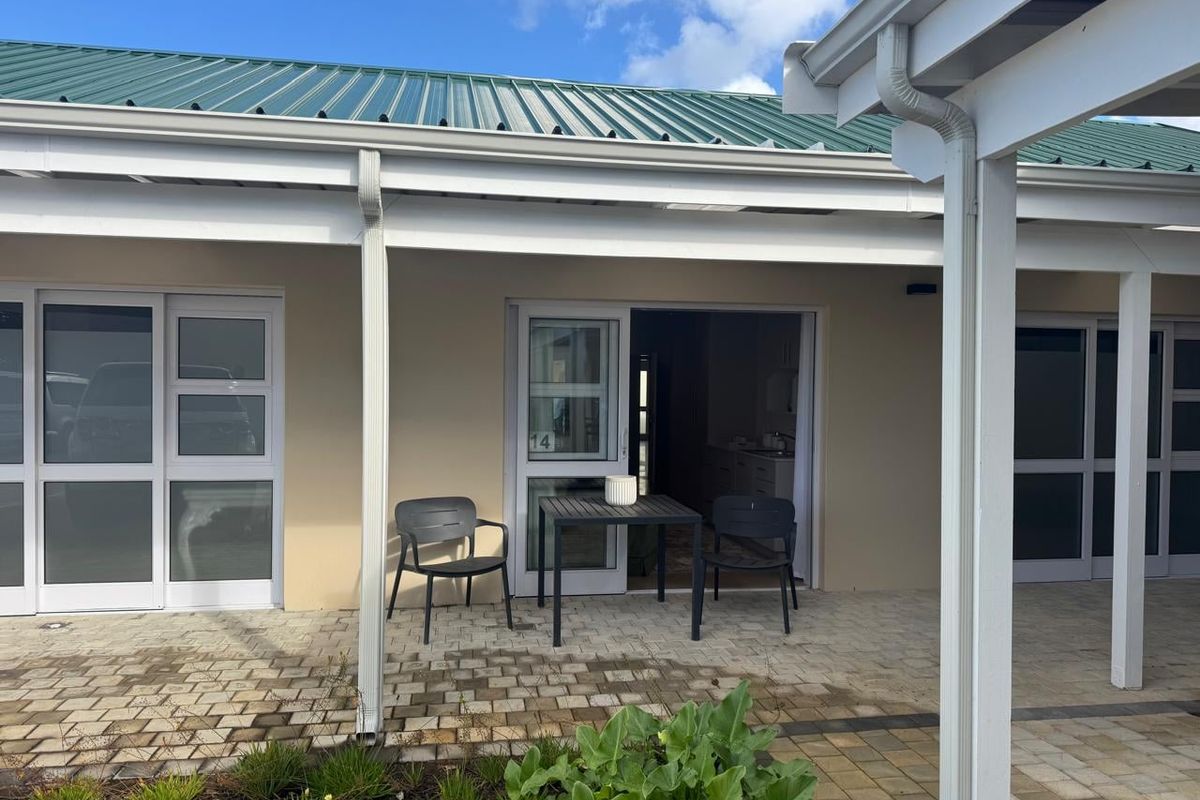 A covered patio area featuring paved flooring and direct access to the unit, providing a functional outdoor space for relaxation.
