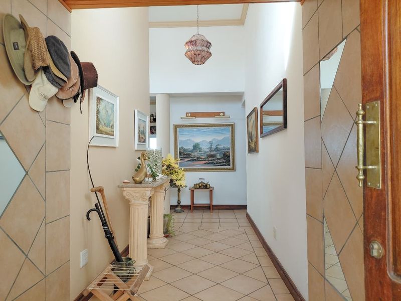 A welcoming entrance hall featuring tiled flooring, decorative wall accents, and a classic timber door frame, leading into the main living areas.