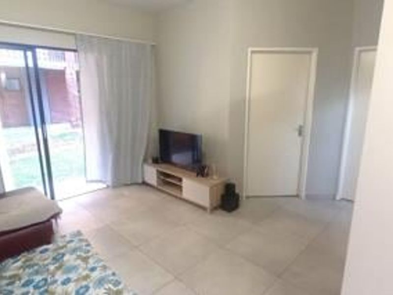 A living room featuring tiled flooring and a sliding glass door providing access to the exterior area.