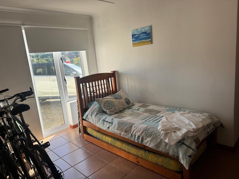 A functional bedroom featuring tiled flooring and a sliding glass door providing direct access to the exterior.