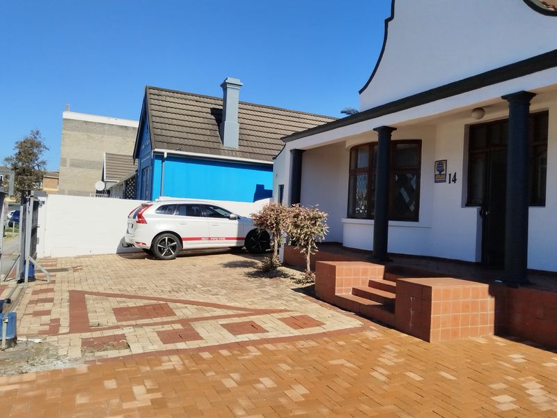 Front exterior view of the property featuring a paved driveway, covered porch with pillars, and tiled entrance steps.