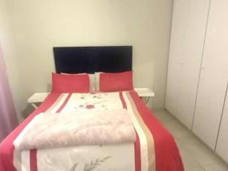 A bedroom featuring built-in cupboards and tiled flooring, providing functional storage space within the apartment.