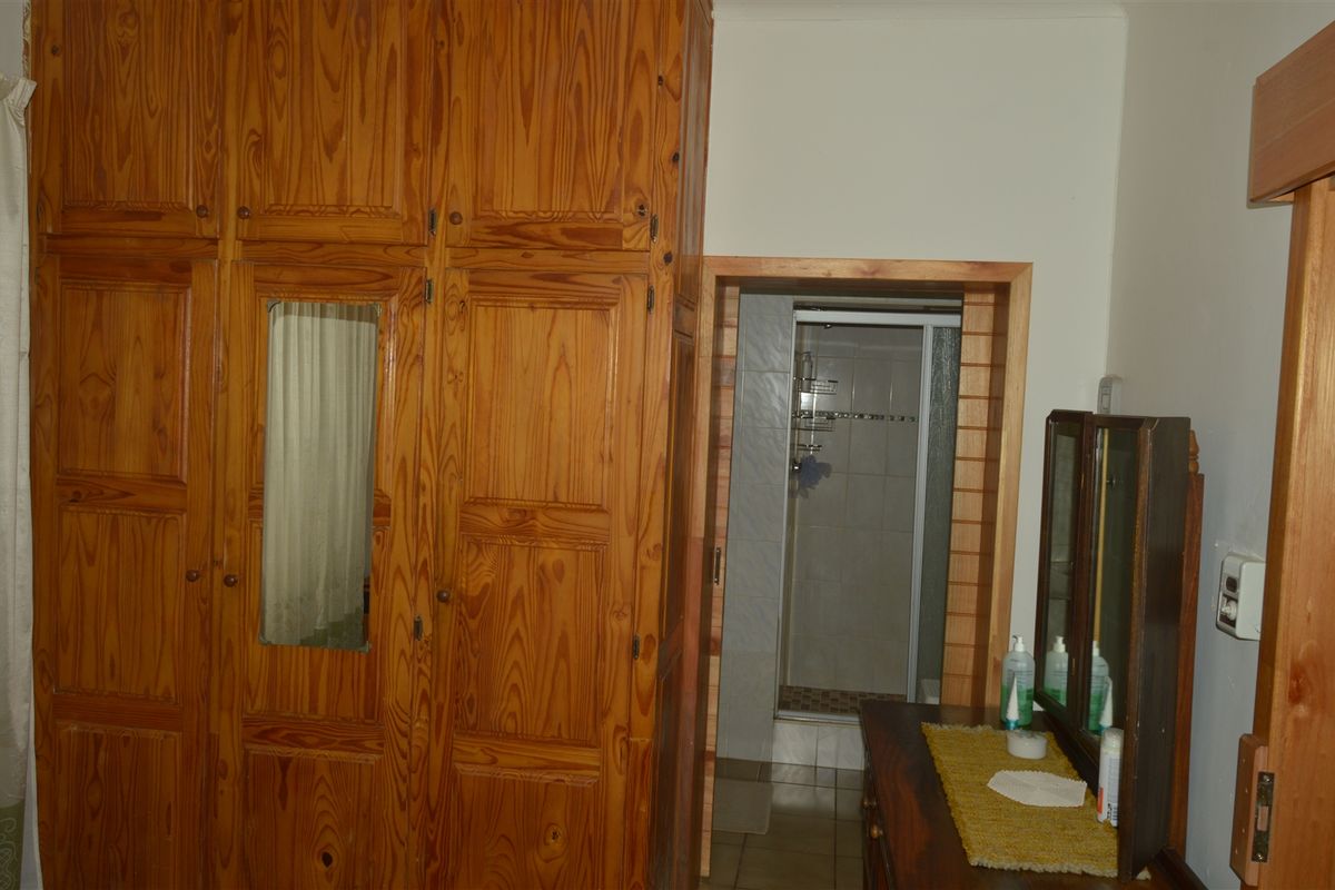 Bedroom featuring a large built-in wooden wardrobe and direct access to an en-suite shower room.
