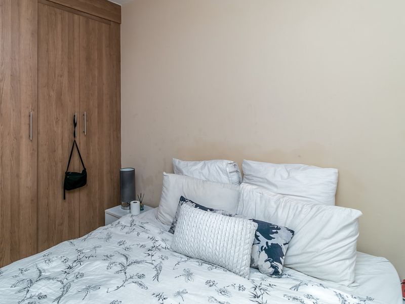 A bedroom featuring built-in wooden cabinetry and neutral wall finishes.