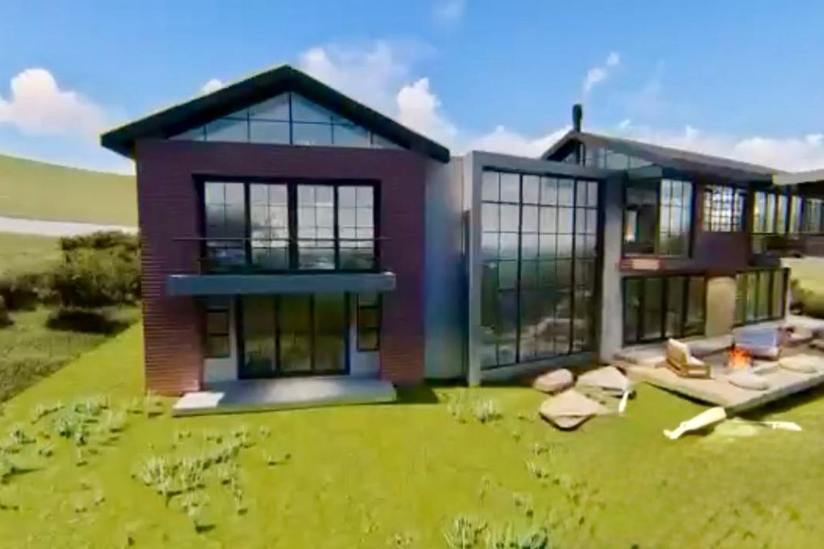 A modern architectural residence featuring expansive glass windows, brick exterior, and a spacious timber deck overlooking the surrounding landscape.