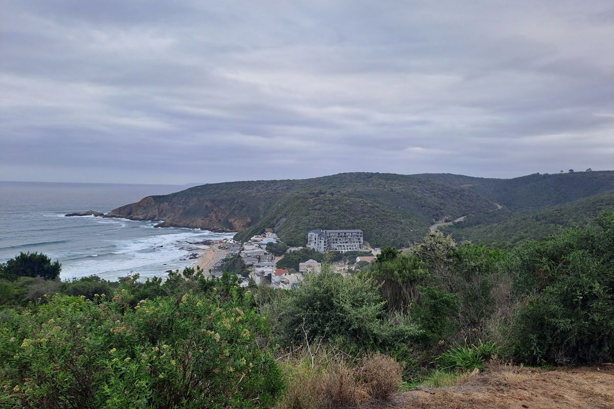 A scenic elevated view overlooking the coastline, surrounding hills, and nearby residential development.