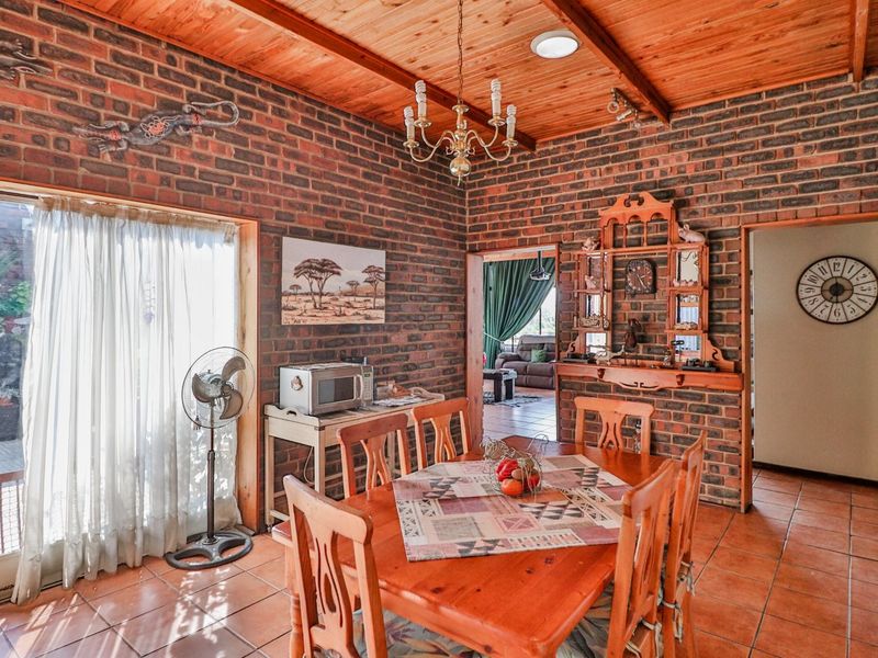Dining room featuring exposed brick walls, timber ceiling with exposed beams, and terracotta floor tiles, with direct access to the outdoor area.