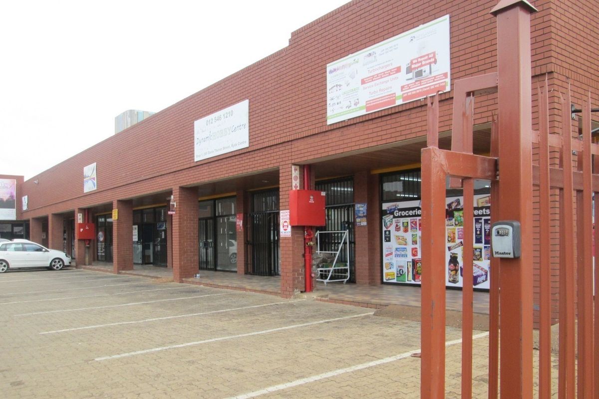 Front exterior view of a commercial office and retail strip center featuring brick construction, paved parking, and secure glass storefront entrances.