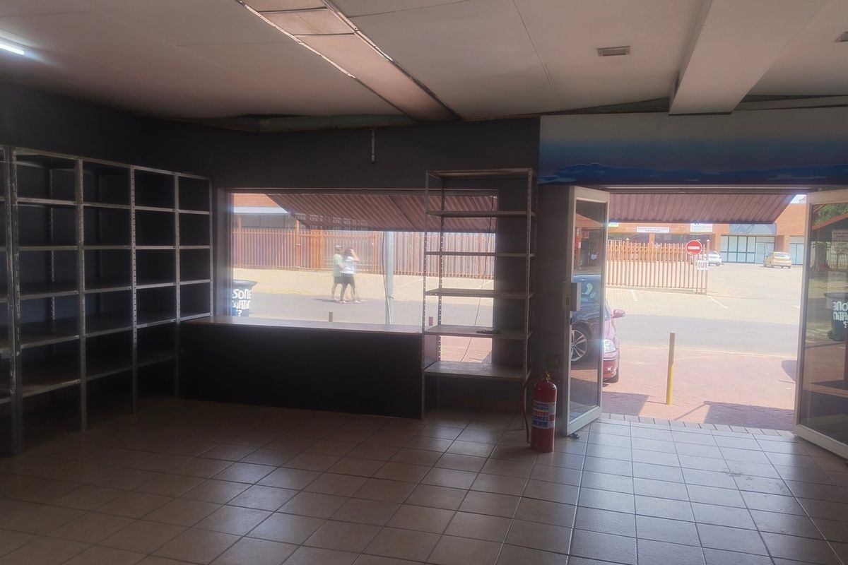 Empty office space featuring tiled flooring, a suspended ceiling, and a large display window with direct street access.