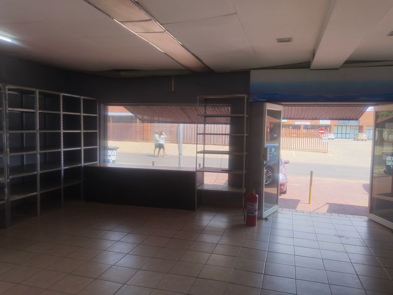 Empty office space featuring tiled flooring, a suspended ceiling, and a large display window with direct street access.