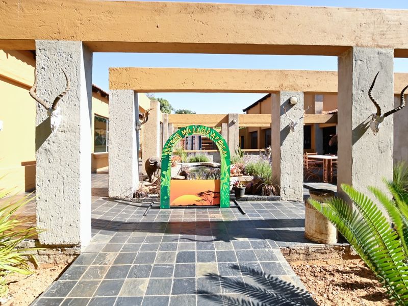 An open-air courtyard area featuring a concrete pergola structure and slate tile flooring, providing a unique outdoor space for the office property.