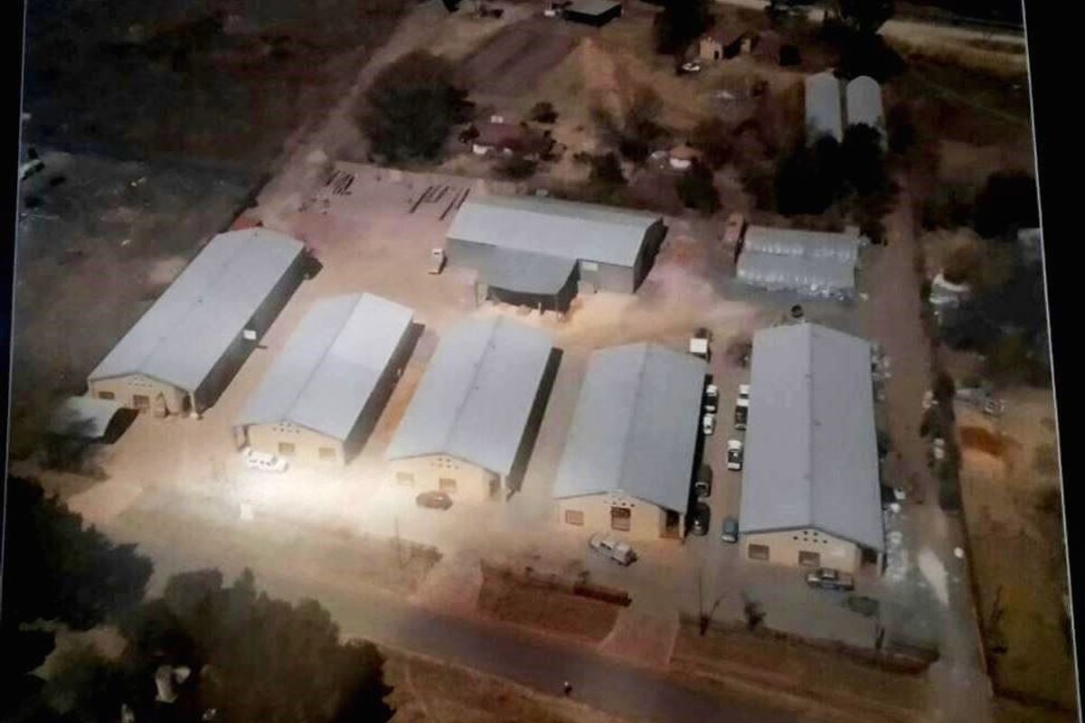 Aerial view of an industrial property complex featuring multiple warehouse structures with metal roofing and surrounding access roads.