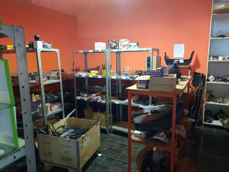 A utility or storage space featuring tiled flooring and multiple metal shelving units used for inventory organization.