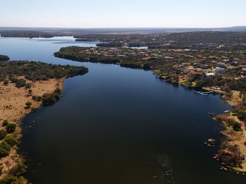 An aerial view of the expansive waterfront landscape, showcasing the natural surroundings and proximity to the residential estate.