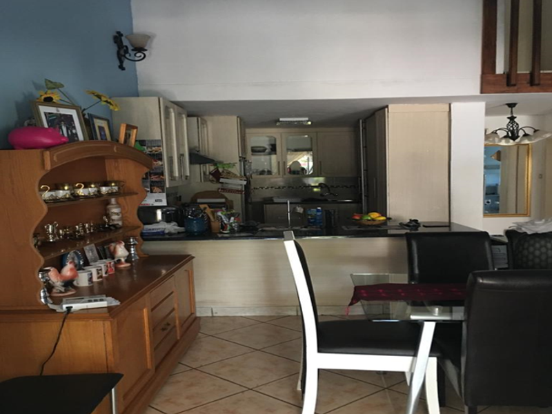Open plan kitchen and dining area featuring tiled flooring, built-in cabinetry, and a breakfast bar counter.