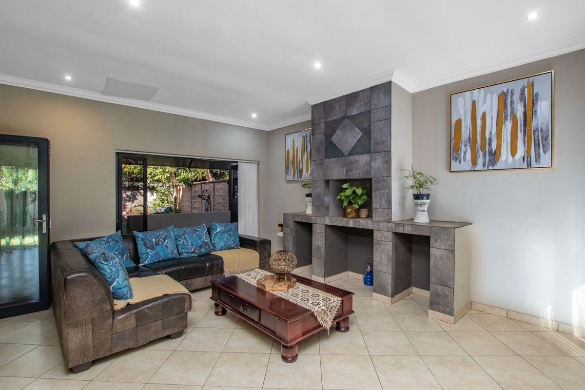 Spacious living room featuring a large tiled fireplace surround, recessed downlighting, and sliding glass doors providing direct access to the outdoor patio area.