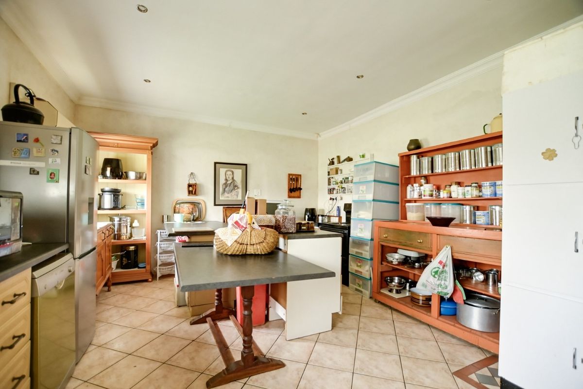 A functional kitchen space featuring tiled flooring, recessed lighting, and ample built-in cabinetry, offering a practical layout for daily culinary activities.